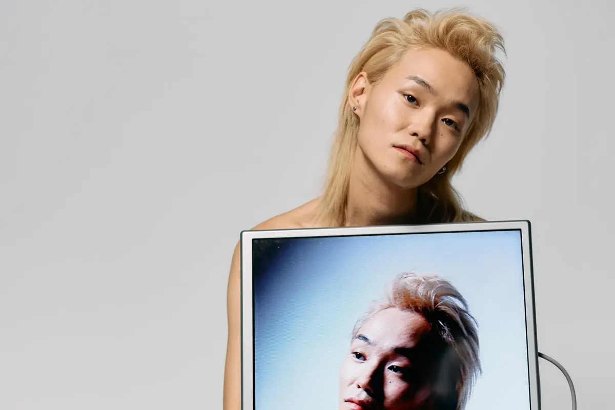 Fashionable Asian model showcasing tech style in a studio shoot.