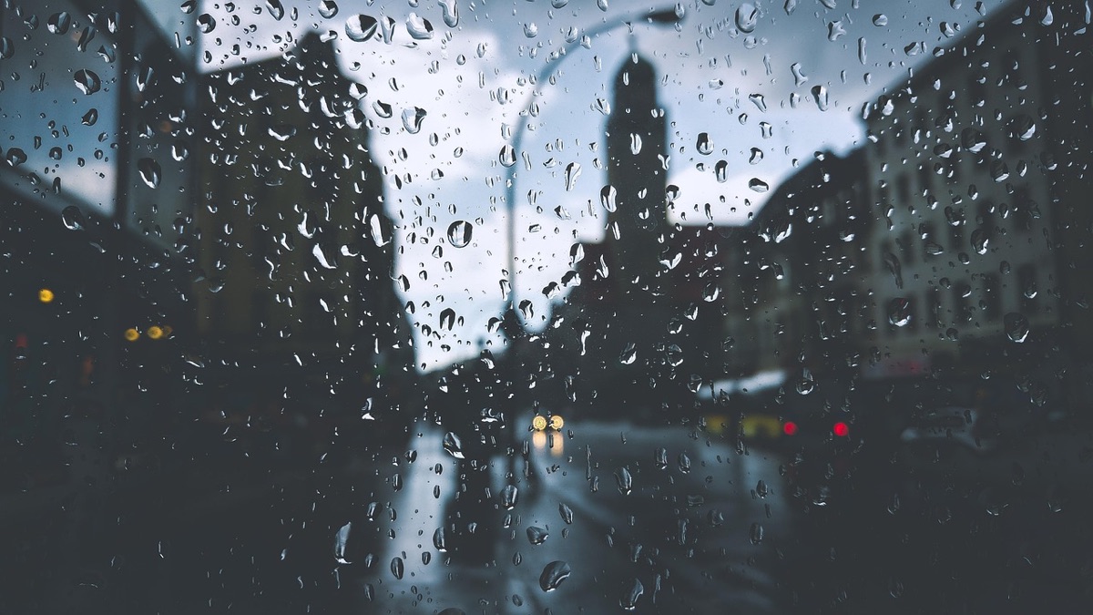Fenêtre sous la pluie avec lumières de ville