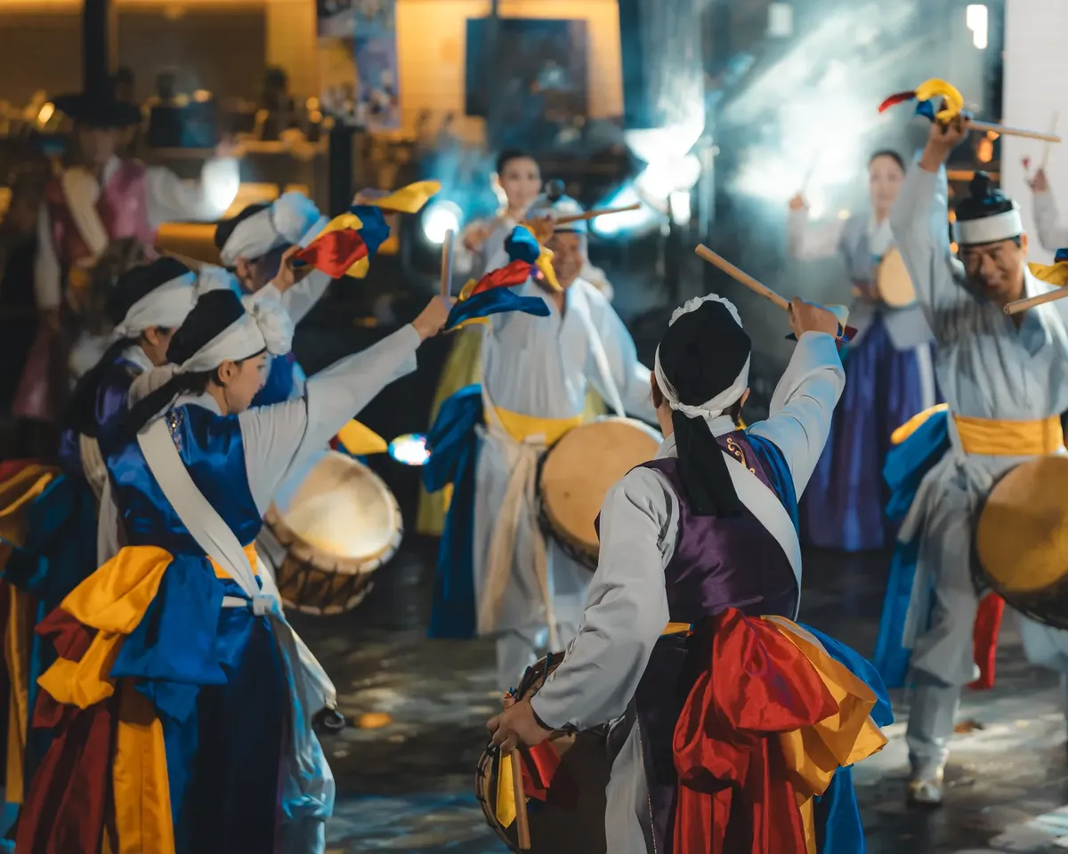 외부에서 진행되는 화려한 전통 한국 춤을 맡은 그룹 with colorful costumes and drums.